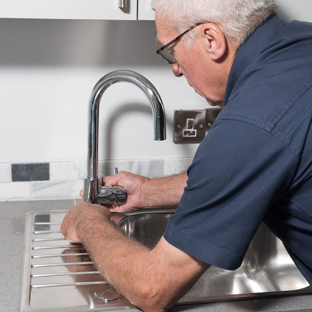 A Taskforce engineer applying manual tools to a tap.