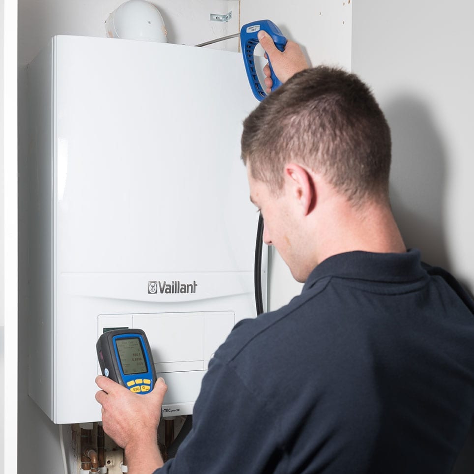 A Taskforce engineer taking a reading on top of a newly installed Vaillant boiler.