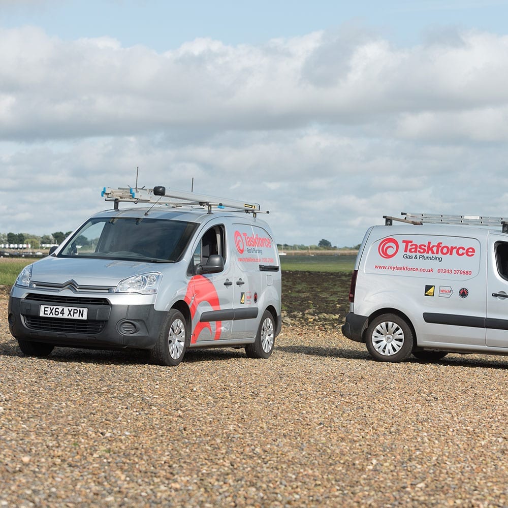 Two of Taskforce's vans parked adjacent to one another on a gravel road.