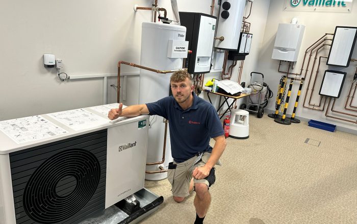 Sonny kneeling by Air Source Heat Pump