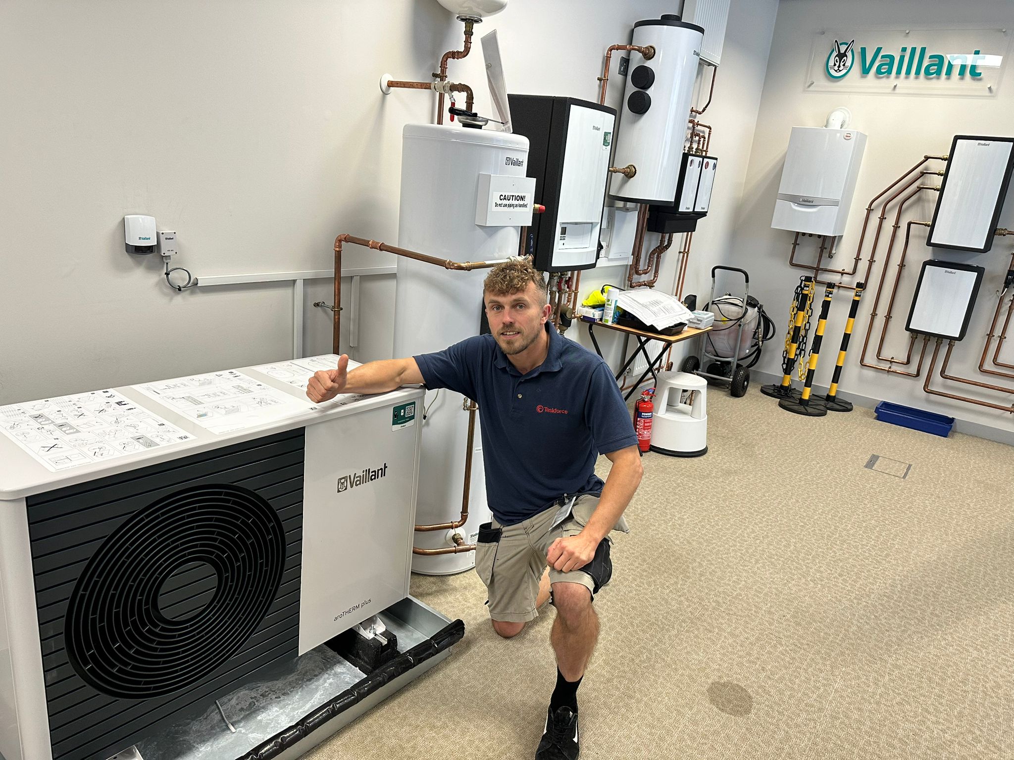 Sonny kneeling by Air Source Heat Pump